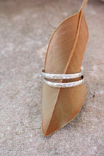 Load image into Gallery viewer, Silver hoop earrings on a brown leaf against a neutral background