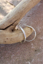 Load image into Gallery viewer, Silver hoop earrings on a piece of driftwood