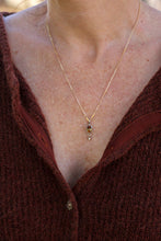 Load image into Gallery viewer, Close-up of a person wearing a gold necklace with a pendant.