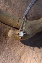 Load image into Gallery viewer, Necklace with a opal and garnet pendant on a wooden surface