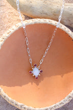 Load image into Gallery viewer, Necklace with a opal and garnet pendant in a pink leather bowl.