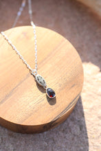 Load image into Gallery viewer, Necklace with a red gemstone pendant on a wooden surface