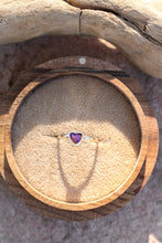 Load image into Gallery viewer, Heart-shaped purple opal gemstone ring in a wooden box with sand.