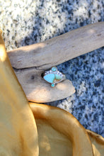 Load image into Gallery viewer, Ring with turquoise colored stone on a piece of driftwood with golden fabric in the foreground