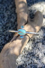 Load image into Gallery viewer, Silver bracelet with turquoise colored stones on a piece of driftwood.