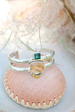 Load image into Gallery viewer, Statement cuff with brown and green stone on a pink leather bowl