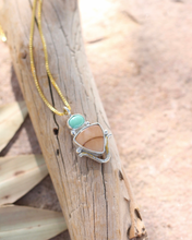 Load image into Gallery viewer, Necklace with a pendant featuring a turquoise and jasper stone on a wooden surface
