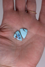 Load image into Gallery viewer, Two turquoise stones held in a hand with a plain background
