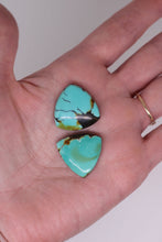 Load image into Gallery viewer, Turquoise stones held in a hand with a plain background
