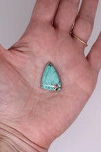 Load image into Gallery viewer, Turquoise stone held in a hand against a neutral background
