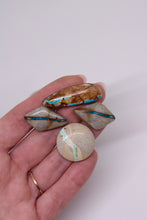 Load image into Gallery viewer, Hand holding four turquoise stones with on a white background
