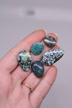 Load image into Gallery viewer, Hand holding five different colored stones against a neutral background
