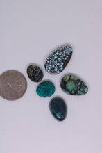 Load image into Gallery viewer, Five turquoise stones of various sizes on a white background with a quarter for scale.
