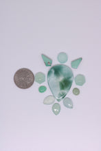 Load image into Gallery viewer, Collection of green stones on a white background with a coin for scale.
