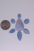 Load image into Gallery viewer, Chalcedony gemstone with teardrop shape and pointed ends, size comparison with a quarter coin.
