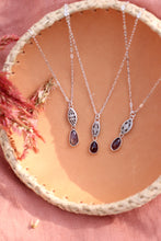 Load image into Gallery viewer, Three silver necklaces with gemstone pendants on a woven surface.
