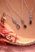 Load image into Gallery viewer, Three silver necklaces with gemstones on a pink surface
