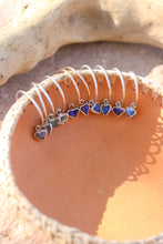 Load image into Gallery viewer, Set of mixed metal hoop earrings with colorful heart opal charms inside a pink leather bowl
