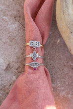 Load image into Gallery viewer, Three rings with gemstones on a pink fabric background
