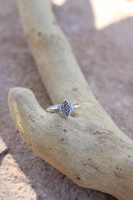 Load image into Gallery viewer, Silver ring with a vintage component  design next to two baguette diamonds on a piece of driftwood on a stone surface
