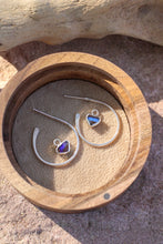 Load image into Gallery viewer, Silver earrings with heart-shaped gemstones in a wooden box on a stone surface
