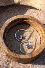 Load image into Gallery viewer, Wooden box with silver earrings featuring blue opal stones on a sandy surface
