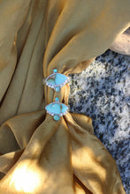 Load image into Gallery viewer, Turquoise colored stone rings on a gold fabric background
