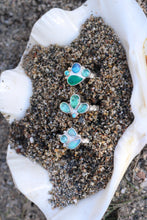 Load image into Gallery viewer, Three silver rings on sand inside a shell.
