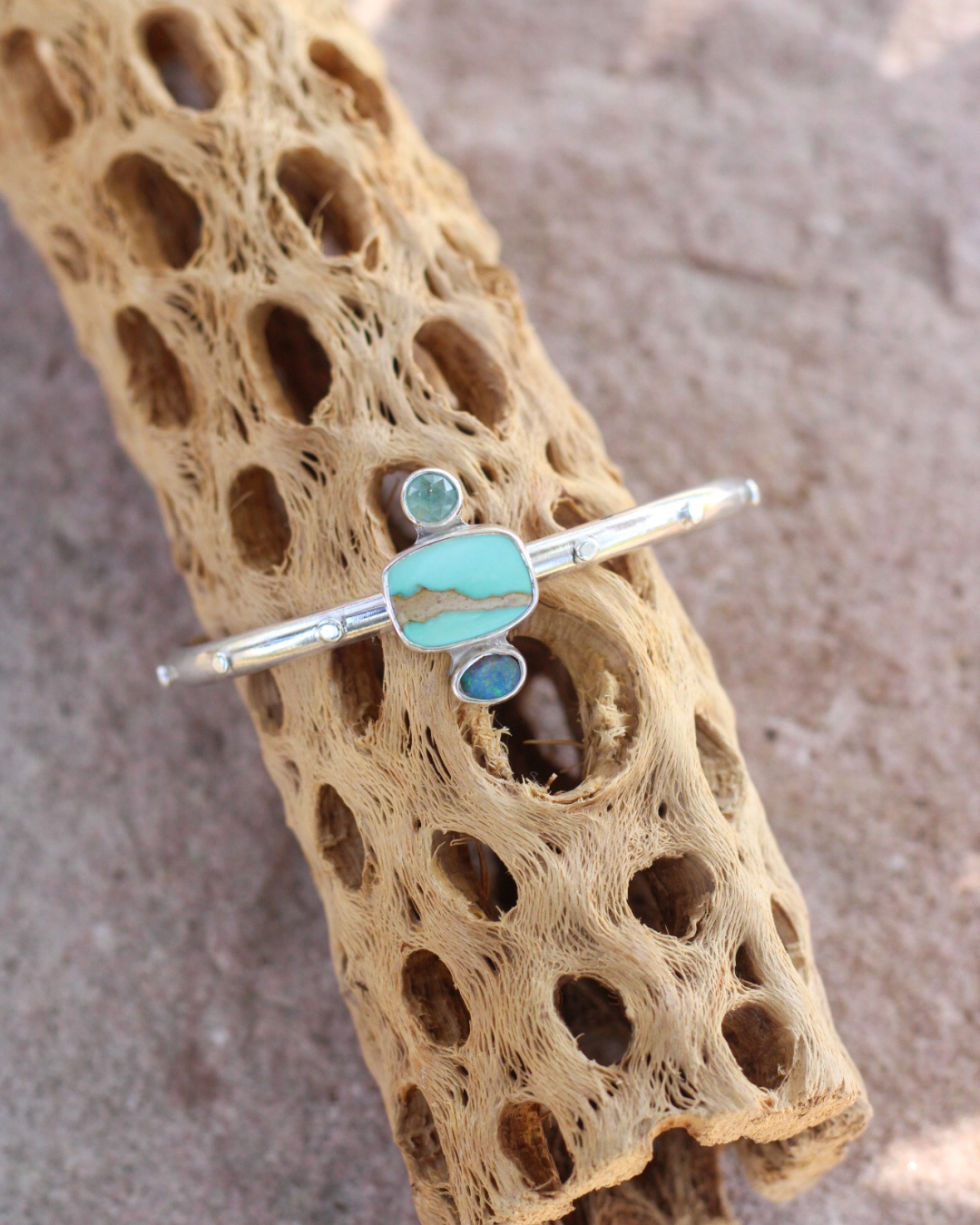 Turquoise colored stone bracelet on a textured brown surface